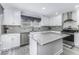 A bright kitchen features white cabinets, stainless appliances, and a gray countertop island at 1119 Albemarle Cir, Noblesville, IN 46062