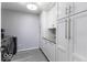 A laundry room with modern washer and dryer, storage cabinets, and folding counter at 1119 Albemarle Cir, Noblesville, IN 46062