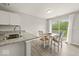 Bright dining area features wood floors, granite counters, white cabinets and sliding glass doors to the outdoors at 11199 Boston Way, Fishers, IN 46038