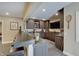 Custom basement bar featuring dark wood cabinetry, stone countertops, seating, and modern appliances at 11508 Willow Ridge Dr, Zionsville, IN 46077