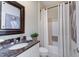 Cozy bathroom featuring granite counters, framed mirror and shower/tub combination with white shower curtain at 11508 Willow Ridge Dr, Zionsville, IN 46077