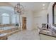 This bathroom features a soaking tub, granite counters, and decorative lighting at 11508 Willow Ridge Dr, Zionsville, IN 46077