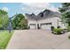 Three car garage, basketball court, and green lawn showcasing a home designed for active Gathering living at 11508 Willow Ridge Dr, Zionsville, IN 46077