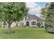 Charming white home surrounded by mature trees and manicured lawn exudes classic elegance and curb appeal at 11508 Willow Ridge Dr, Zionsville, IN 46077