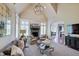 Bright living room with neutral decor, fireplace, large windows and open layout for entertaining guests at 11508 Willow Ridge Dr, Zionsville, IN 46077