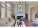 Bright living room featuring a stone fireplace, hardwood floors, plantation shutters, and sophisticated decor at 11508 Willow Ridge Dr, Zionsville, IN 46077