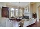 Elegant living room with hardwood floors, stone fireplace, plantation shutters, and a decorative chandelier at 11508 Willow Ridge Dr, Zionsville, IN 46077