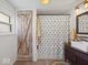 Charming bathroom featuring a rustic barn door and patterned shower curtain at 116 E Railroad St, Fountaintown, IN 46130