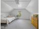Finished attic space features bed, dresser, natural light, and neutral color palette at 116 E Railroad St, Fountaintown, IN 46130