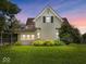 Charming home featuring a well-manicured lawn and delightful landscaping at dusk at 116 E Railroad St, Fountaintown, IN 46130