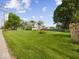 View of house exterior with large grassy lawn, trees, blue sky, and telephone pole at 116 E Railroad St, Fountaintown, IN 46130
