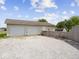 The exterior of a 2-car garage with a gravel driveway, fenced yard, and a sunny sky at 116 E Railroad St, Fountaintown, IN 46130