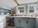 Bright kitchen with blue cabinets, concrete counters and patterned wallpaper at 116 E Railroad St, Fountaintown, IN 46130