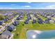 Vast aerial view of a suburban community, highlighting the green spaces, pond, and single-Gathering homes at 13410 Mancroft Dr, Fishers, IN 46037