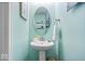 Stylish powder room with a pedestal sink, oval mirror, and modern fixtures at 13410 Mancroft Dr, Fishers, IN 46037
