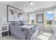 A grey bedroom is furnished with neutral bedding, light wood-look floors, and art at 13410 Mancroft Dr, Fishers, IN 46037