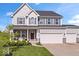 Charming two-story home featuring gray siding, a three-car garage, well-manicured lawn and stone accents at 13410 Mancroft Dr, Fishers, IN 46037
