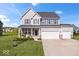 Charming two-story home featuring gray siding, a three-car garage, well-manicured lawn and stone accents at 13410 Mancroft Dr, Fishers, IN 46037