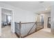 Spacious hallway with decorative metal railing, leading to bedrooms at 13410 Mancroft Dr, Fishers, IN 46037