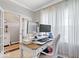 Bright home office with a white desk, modern monitor setup, and sheer curtains at 13410 Mancroft Dr, Fishers, IN 46037