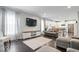 Open-concept living room featuring dark wood floors, neutral decor, and a seamless flow to the kitchen at 13410 Mancroft Dr, Fishers, IN 46037