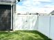 New, white vinyl privacy fence encloses backyard with a double gate at the side of the dark gray home at 135 Crestwood Ave, Crawfordsville, IN 47933