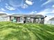 This spacious backyard is covered in green grass and features a patio with seating and a grill at 135 Crestwood Ave, Crawfordsville, IN 47933