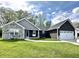 Charming home with stone accents, dark siding, a well-manicured lawn, and a convenient two-car attached garage at 135 Crestwood Ave, Crawfordsville, IN 47933