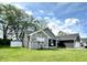 Well-manicured front lawn and landscaped yard with stone and dark gray siding and a white vinyl fence at 135 Crestwood Ave, Crawfordsville, IN 47933