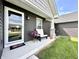 Inviting covered front porch with seating, perfect for relaxing and enjoying the outdoors. Fresh paint and flowers at 135 Crestwood Ave, Crawfordsville, IN 47933
