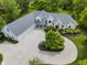 An aerial view of a sprawling property showcasing a white brick home, multi-car garage, and mature landscaping at 13909 Springmill Rd, Carmel, IN 46032