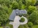 An aerial view showcases the home's circular drive, manicured lawn, and surrounding mature trees at 13909 Springmill Rd, Carmel, IN 46032