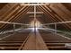 An unfinished attic showcases exposed beams and rafters, providing a glimpse of the home's structure at 13909 Springmill Rd, Carmel, IN 46032