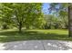 Expansive, well-manicured lawn with mature shade trees, bordered by concrete patio, perfect for relaxation at 13909 Springmill Rd, Carmel, IN 46032