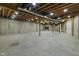 Unfinished basement with exposed ceiling, concrete walls and floors presents a customizable space for future living at 13909 Springmill Rd, Carmel, IN 46032