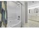 A clean bathroom features a tiled shower-bath, double sink with vanity, and tile flooring at 13909 Springmill Rd, Carmel, IN 46032