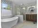 Stylish bathroom featuring standalone tub, glass shower, and wood vanity at 13909 Springmill Rd, Carmel, IN 46032