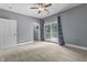 This airy bedroom features carpet, a ceiling fan, and access to a balcony through sliding glass doors at 13909 Springmill Rd, Carmel, IN 46032