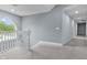 Hallway with white banister, grey carpet, and arched window at 13909 Springmill Rd, Carmel, IN 46032