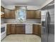 A well-lit kitchen features wooden cabinets, a white appliance suite, and tile flooring at 13909 Springmill Rd, Carmel, IN 46032