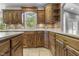 Kitchen featuring custom cabinetry, countertop space, and a window overlooking the backyard at 13909 Springmill Rd, Carmel, IN 46032
