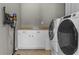A functional laundry room showcases modern appliances, a folding counter, and white cabinets at 13909 Springmill Rd, Carmel, IN 46032