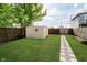 Landscaped backyard features a new shed, lush green grass, a stone paver path, and a wooden privacy fence at 1402 Olive St, Indianapolis, IN 46203