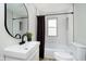 Modern bathroom with white subway tile, black fixtures, and a stylish round mirror at 1402 Olive St, Indianapolis, IN 46203