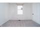 Bright bedroom with a neutral palette, large window, plush carpet, and a classic white door at 1402 Olive St, Indianapolis, IN 46203