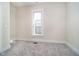 A bedroom with neutral walls, carpet and a large window at 1402 Olive St, Indianapolis, IN 46203