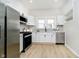Modern kitchen featuring stainless steel appliances, white cabinets, and stylish black hardware at 1402 Olive St, Indianapolis, IN 46203