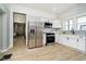 Bright kitchen boasts stainless steel appliances, white cabinetry, and stylish backsplash at 1402 Olive St, Indianapolis, IN 46203