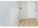 Neat laundry area boasts a washing machine hookup and modern white door, complemented by sleek, light-colored flooring at 1402 Olive St, Indianapolis, IN 46203