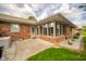 Exterior view of sunroom in brick home with concrete patio and manicured lawn at 143 Asbury Dr # 86A, Anderson, IN 46013
